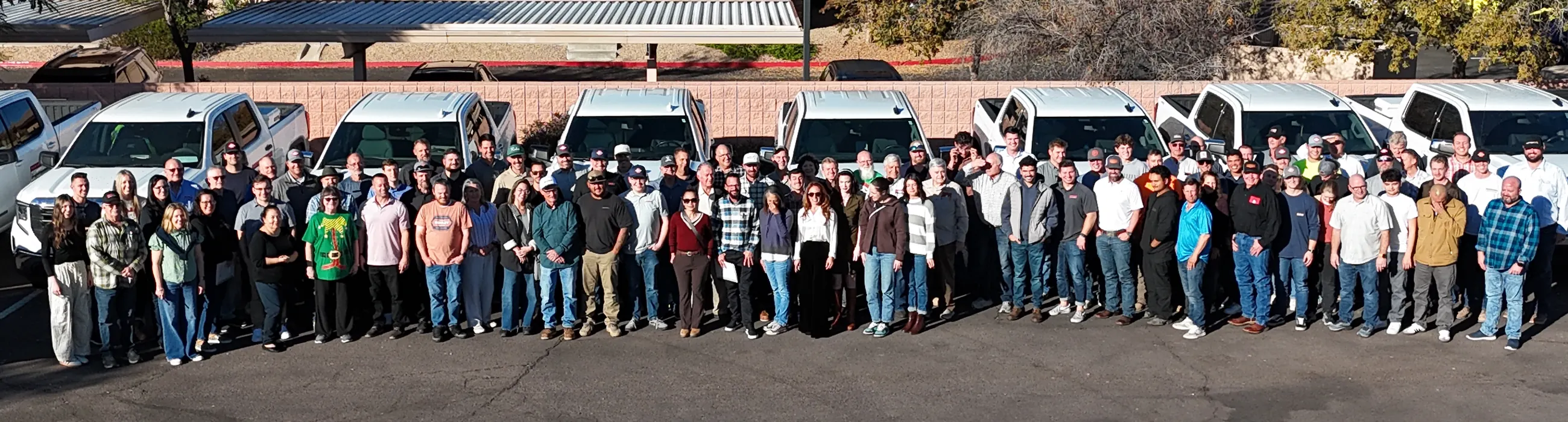 The full Porter Brothers team gathered in front of the company truck fleet outside the office